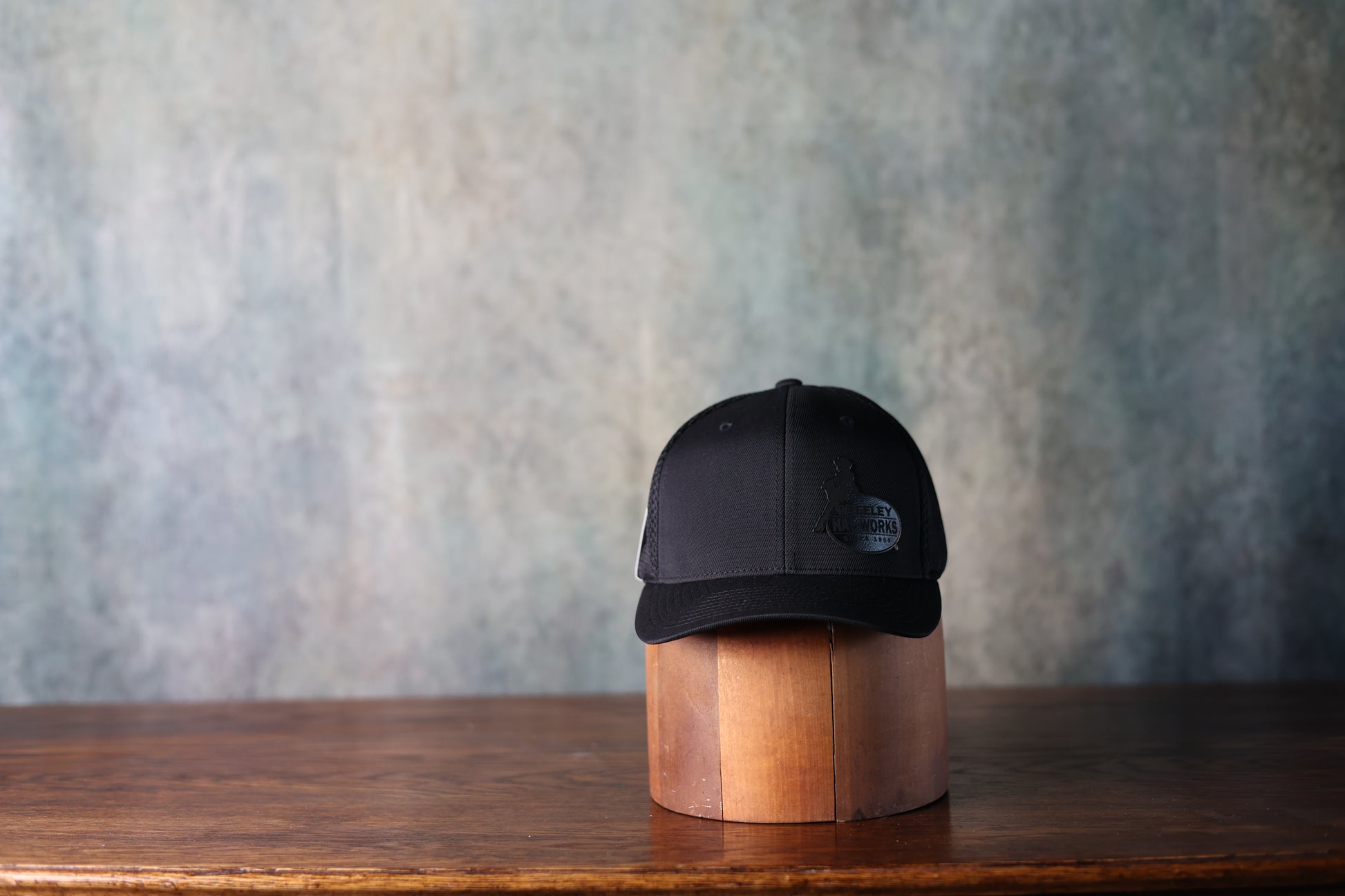Photo of the new black leather patch baseball hat from Greeley Hat Works with the logo in black on black