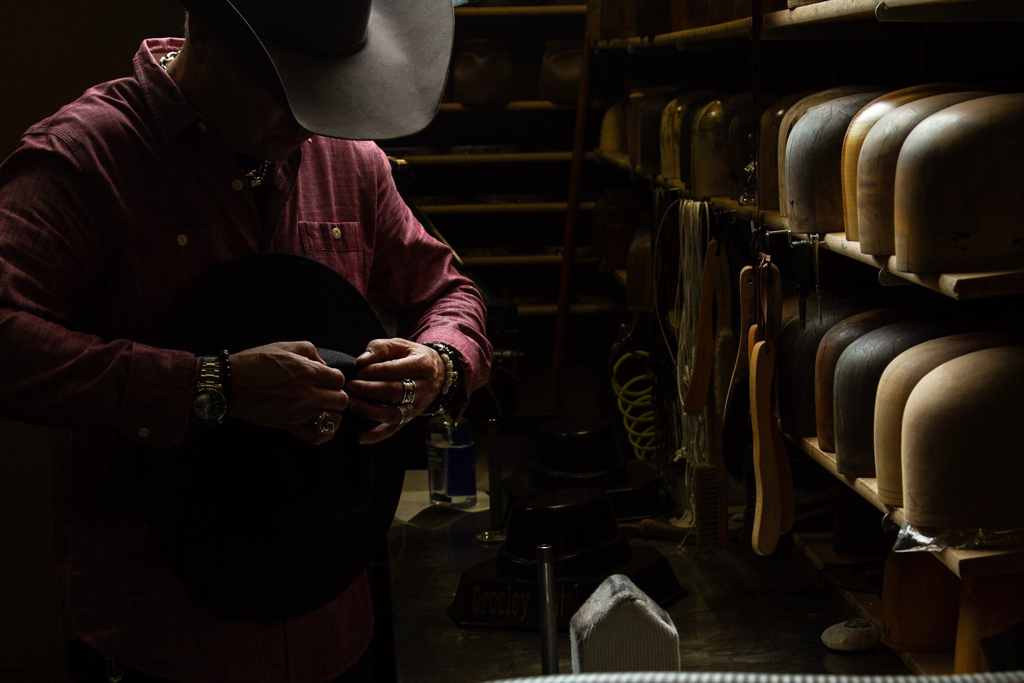 Photo of hatmaker at Greeley Hat Works in Greeley, Colorado shaping a custom cowboy hat in their shop
