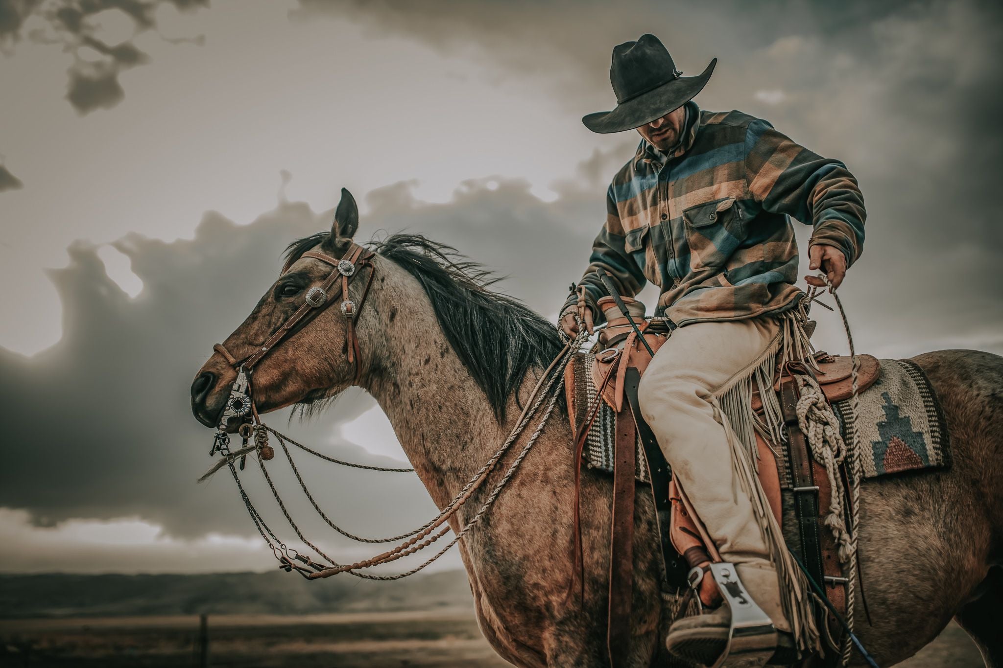 Photo of cowboy riding horse while wearing a custom cowboy hat from Greeley Hat Works