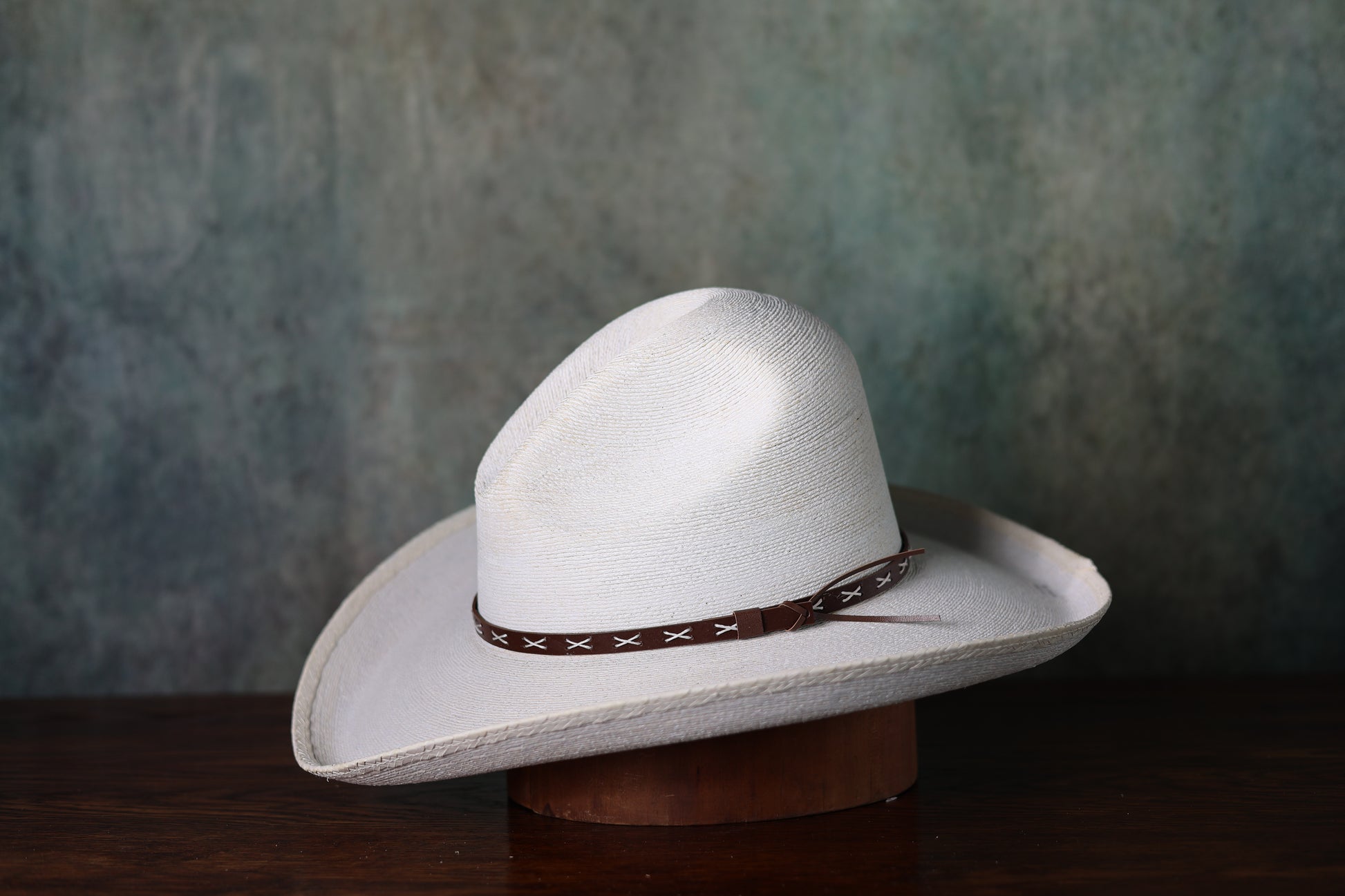 Photo of white SunBody Mexican Fine Palm Gus straw hat from Greeley Hat Works with a brown leather hat band