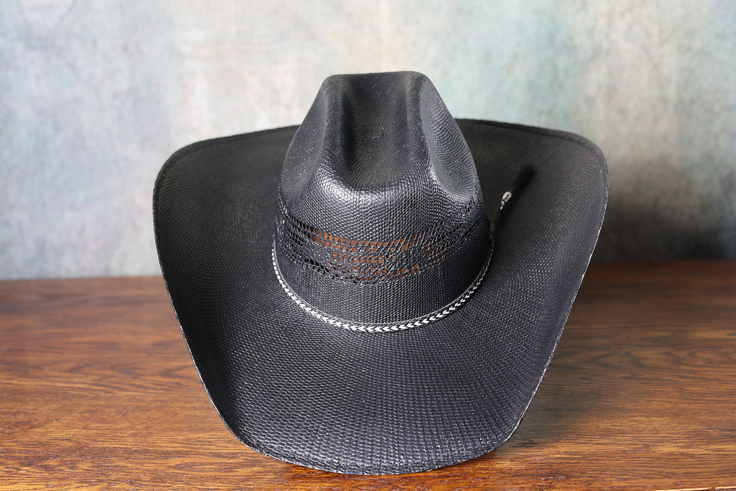 Photo of the top of a Black Bangora Pre-Shape 4 1/2” Brim cowboy hat on a wooden block with a textured gray background