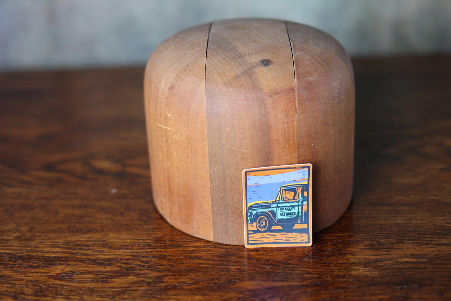 Photo of a stick featuring an antique truck with greeley hat works on the site, leaning on a custom cowboy hat mold