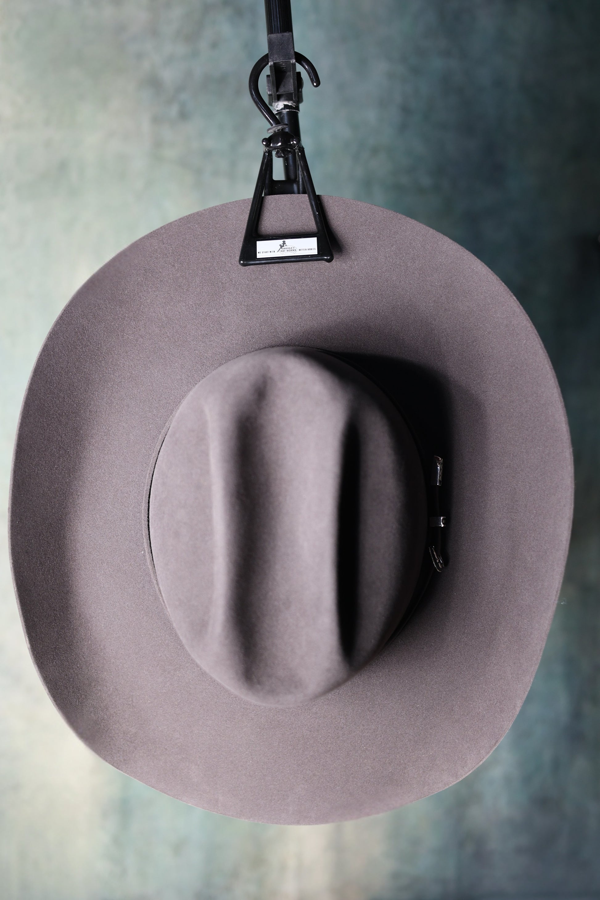 Photo of the Ultimate Hat Hanger from Greeley Hat Works hanging a grey cowboy hat