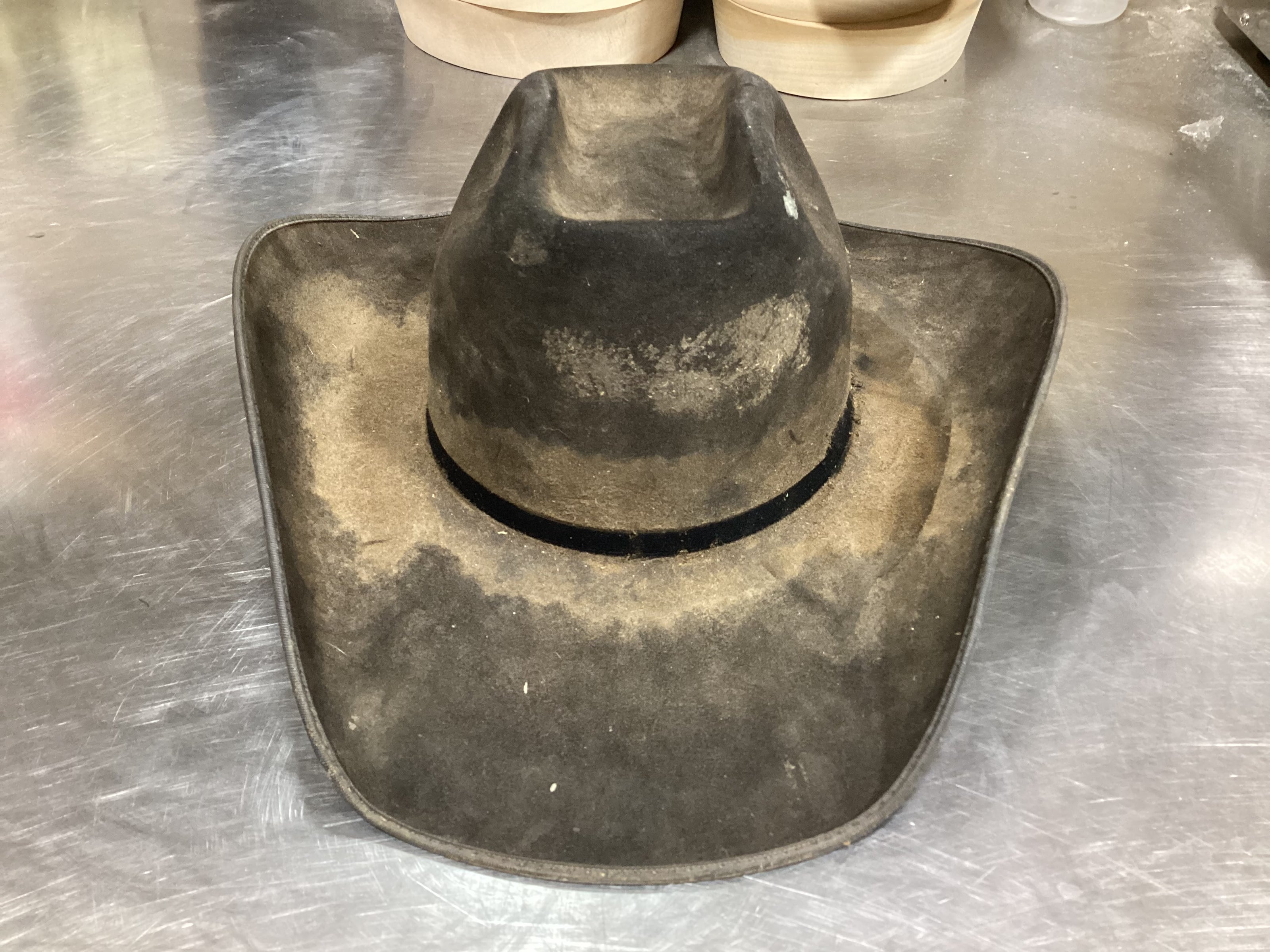 Front photo of dirty cream-colored cowboy hat prior to ReCraft services from Greeley Hat Works